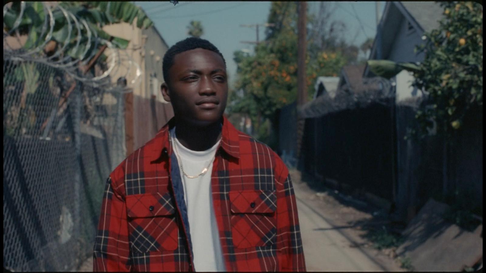 a man standing in front of a fence