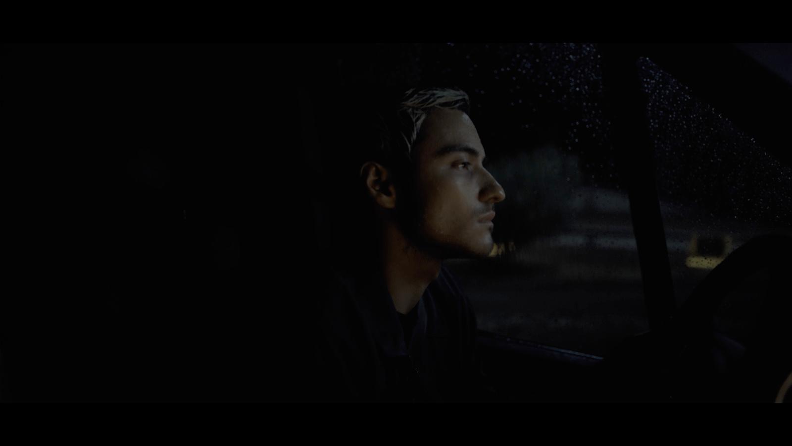 a man sitting in a car in the rain