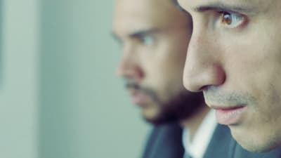 a close up of a person wearing a suit and tie