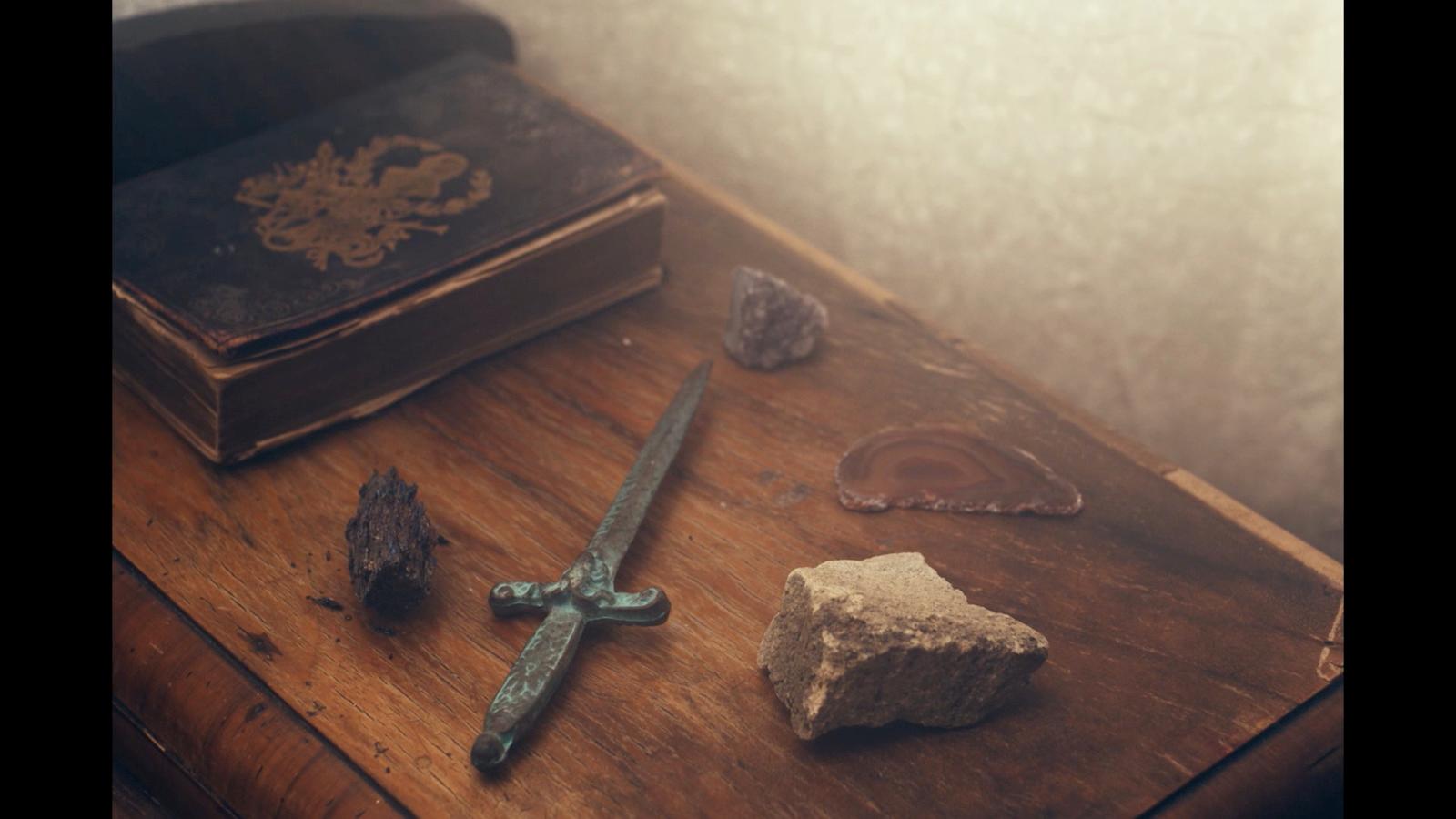a sword and a rock on a table