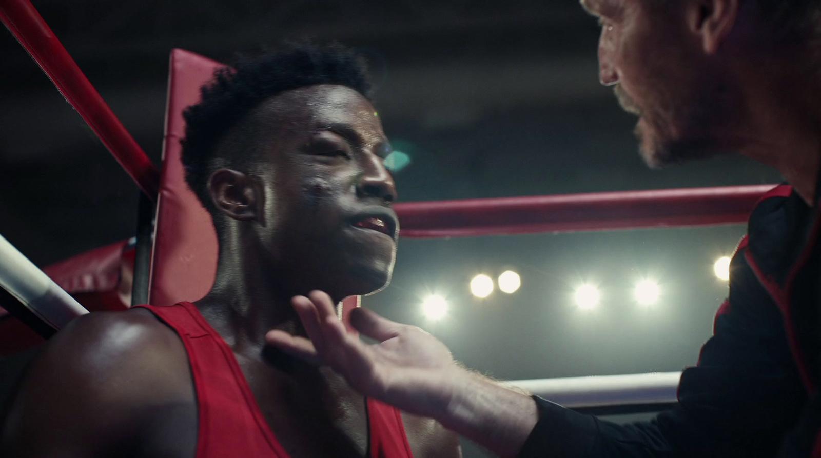 a man standing next to another man in a boxing ring