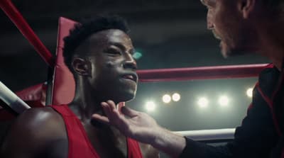 a man standing next to another man in a boxing ring