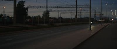 a city street at night with lots of power lines