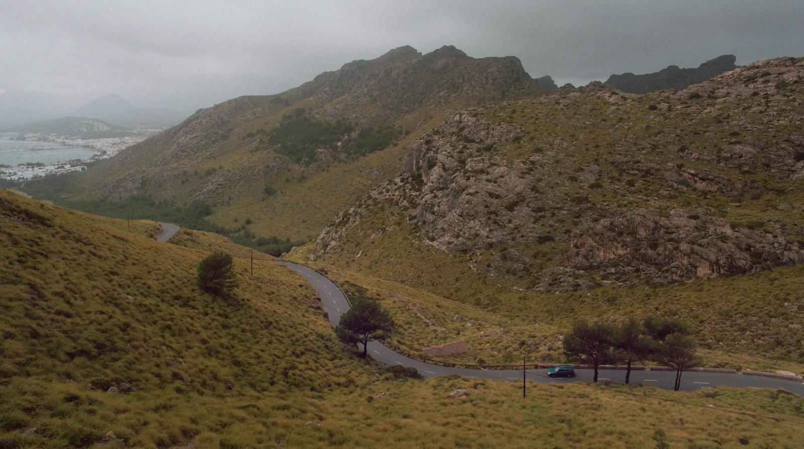 a car driving down a winding road in the mountains