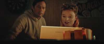 a man and a woman looking at a laptop screen