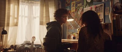 a man and a woman in a room looking at each other