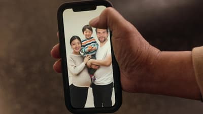 a person holding a cell phone with a picture of a family on it