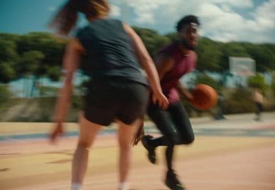 a man and a woman playing basketball on a court