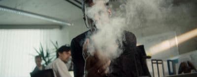 a man standing in front of a laptop computer covered in smoke