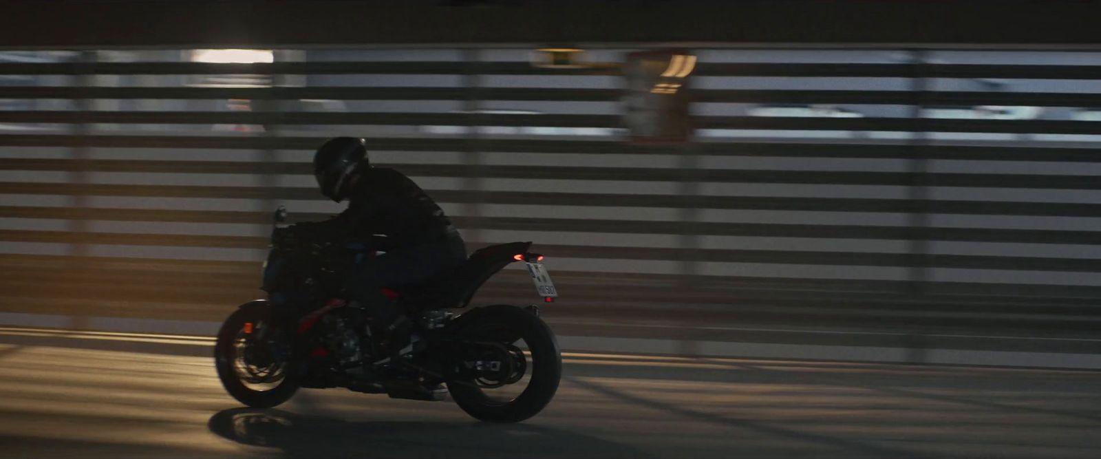 a man riding a motorcycle down a street at night