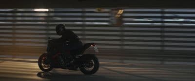 a man riding a motorcycle down a street at night