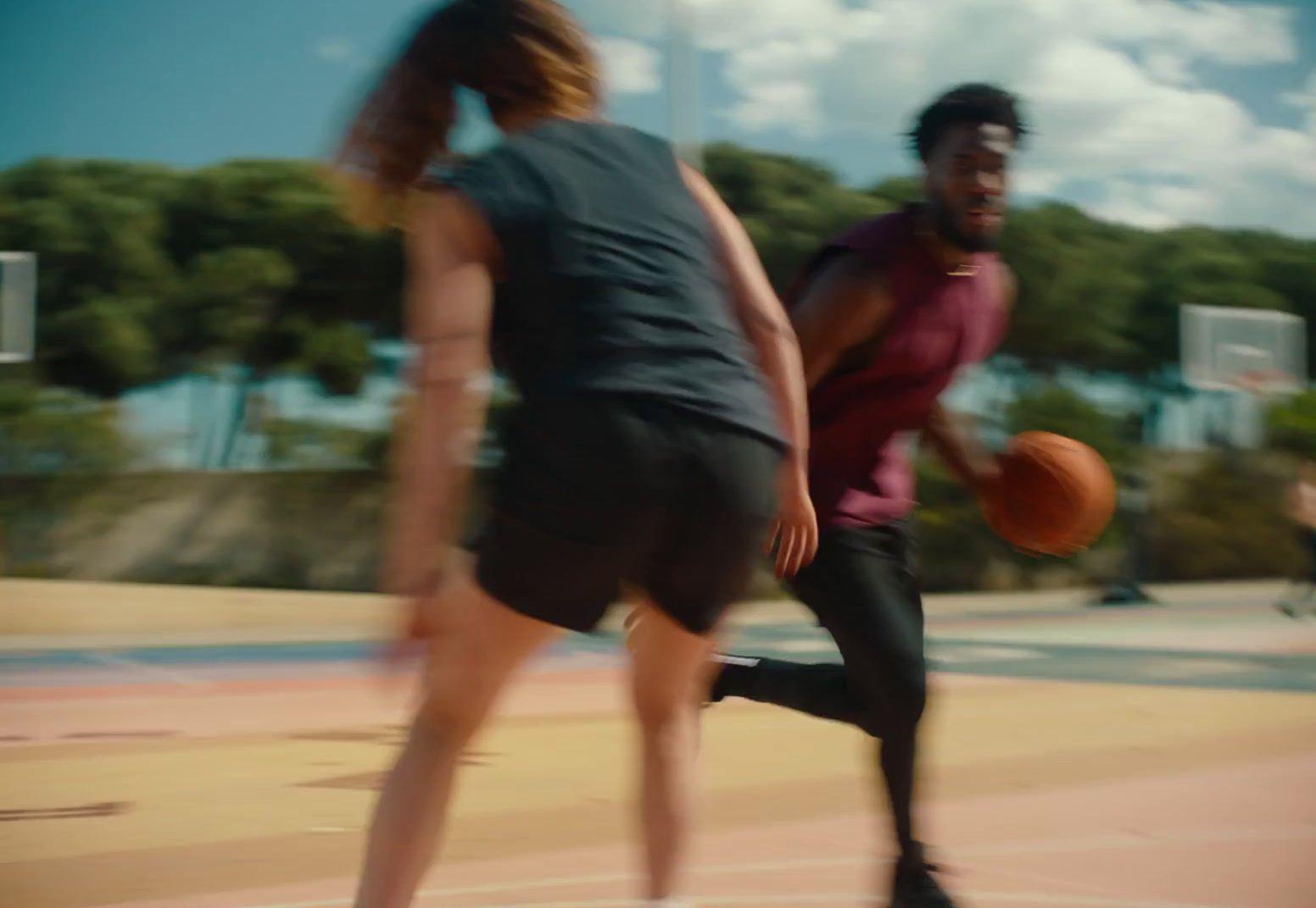 a man and a woman playing basketball on a court