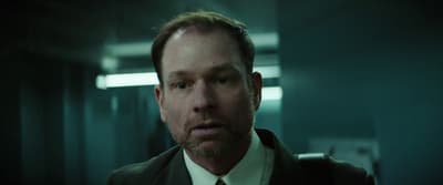 a man in a suit and tie is standing in a hallway