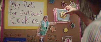 a young girl standing in front of a wall decorated with cookies