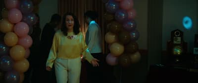 a woman standing in front of balloons in a room