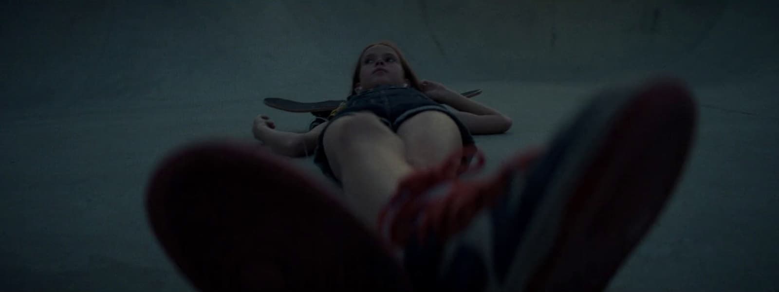 a woman laying on the ground with a knife in her hand