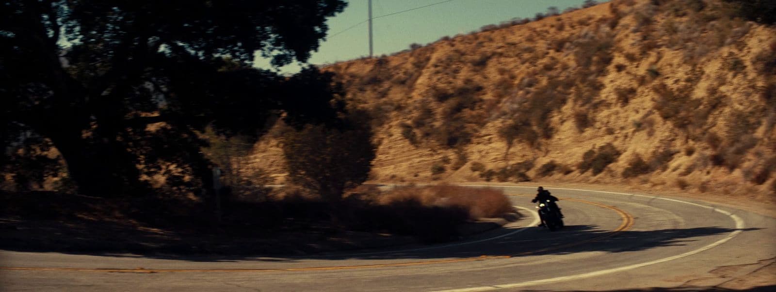 a person riding a motorcycle down a curvy road