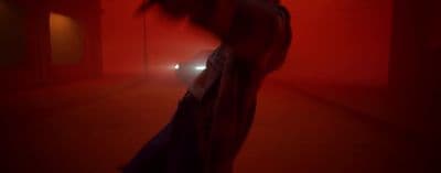 a person standing in a room with a red light