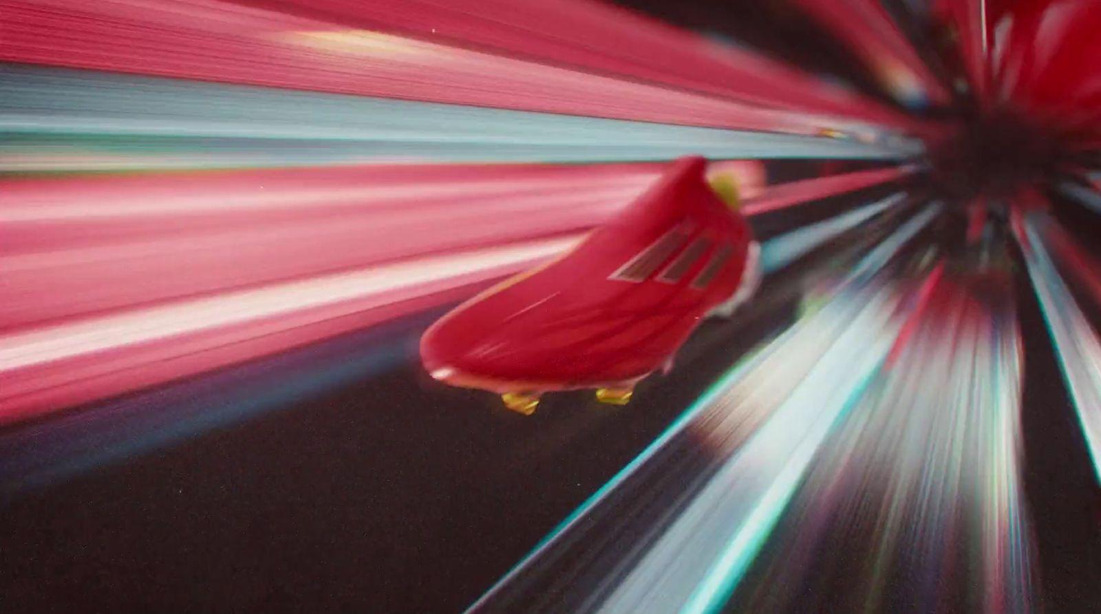 a red car driving through a tunnel of light