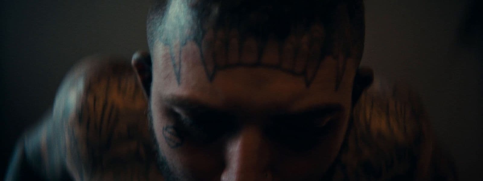 a man with a beard and tattoos on his face