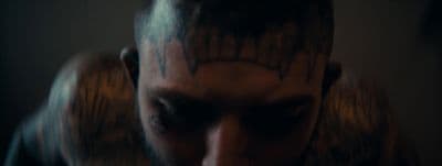 a man with a beard and tattoos on his face