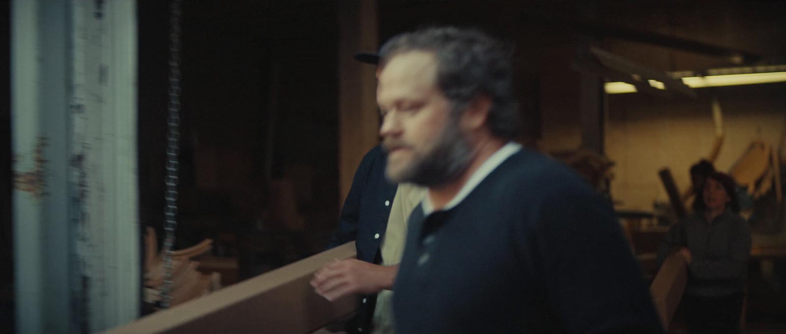 a man is holding a piece of wood in his hands
