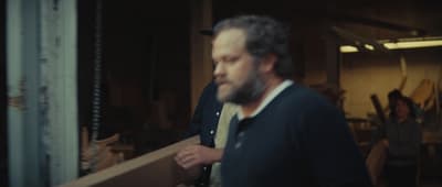a man is holding a piece of wood in his hands
