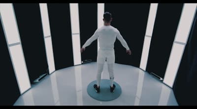 a man in white is standing on a blue object