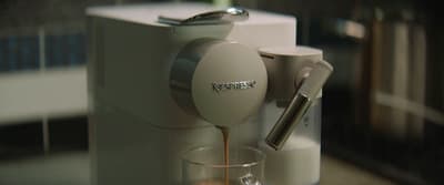 an espresso machine pouring coffee into a glass