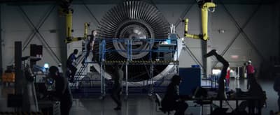 a group of people standing around a machine