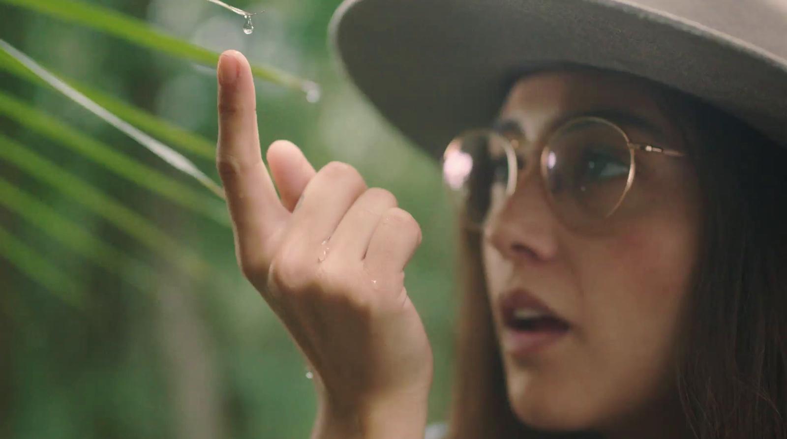 a woman wearing a hat and glasses holding a pair of scissors