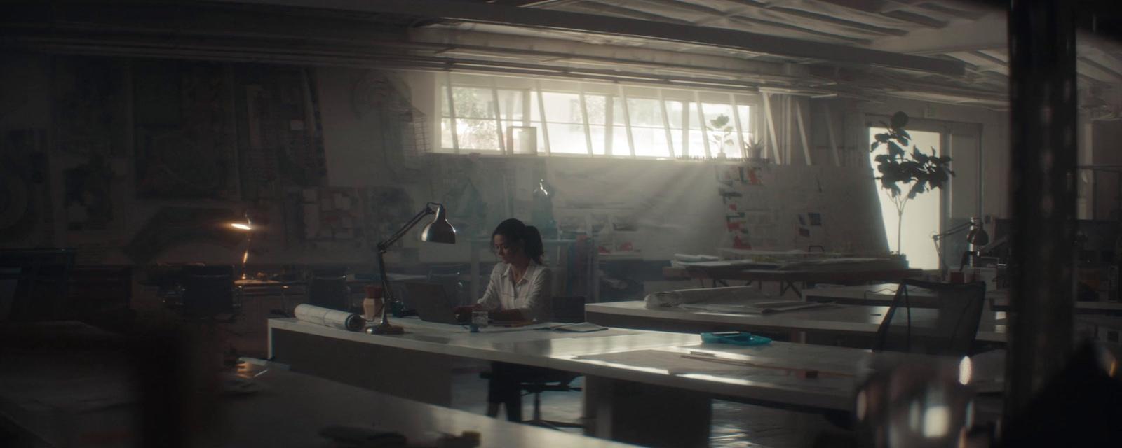 a woman sitting at a desk in a room