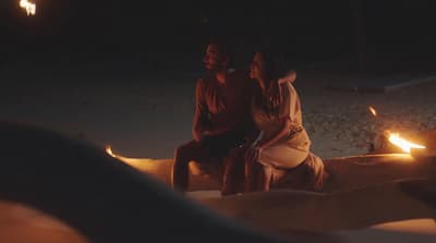 a couple of people sitting on top of a wooden bench