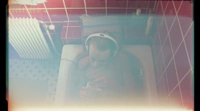 a man sitting in a bathtub with headphones on