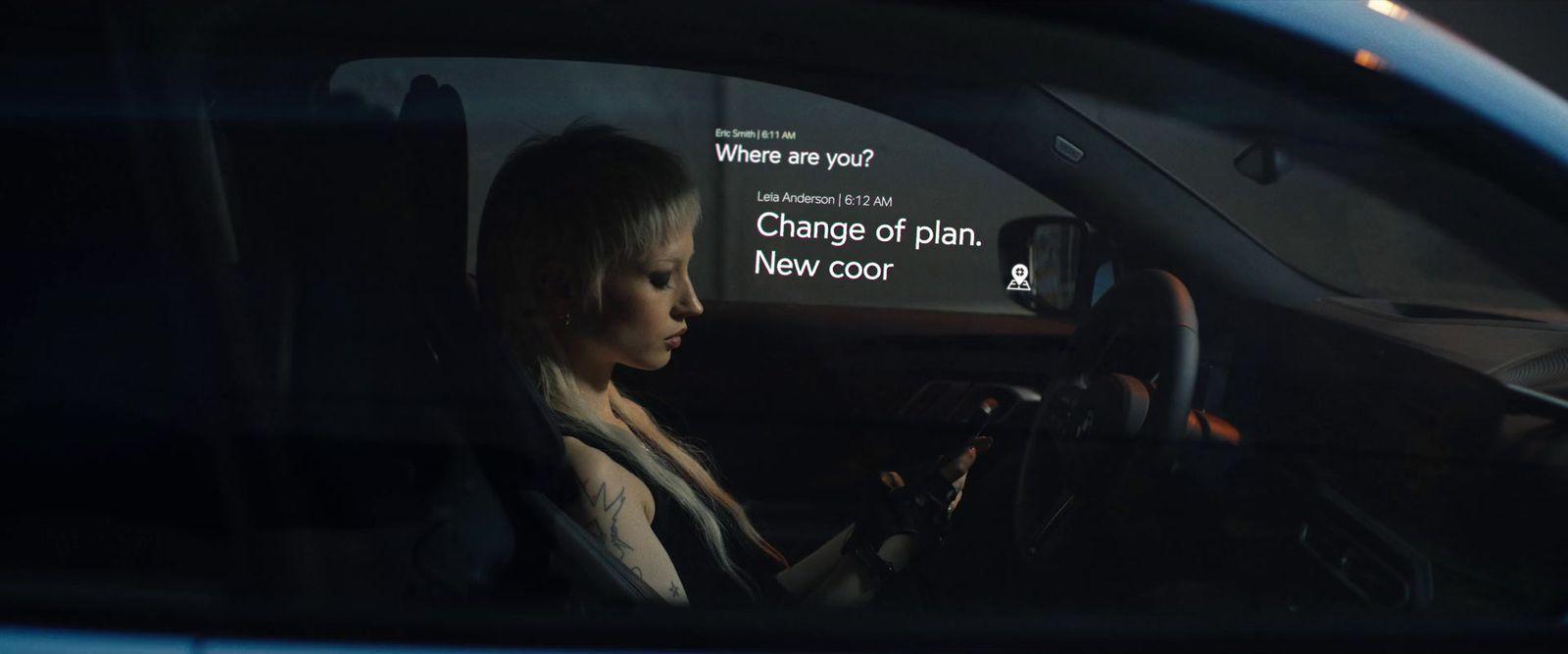 a woman sitting in a car holding a steering wheel