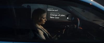 a woman sitting in a car holding a steering wheel