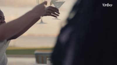 a woman is holding a glass of wine