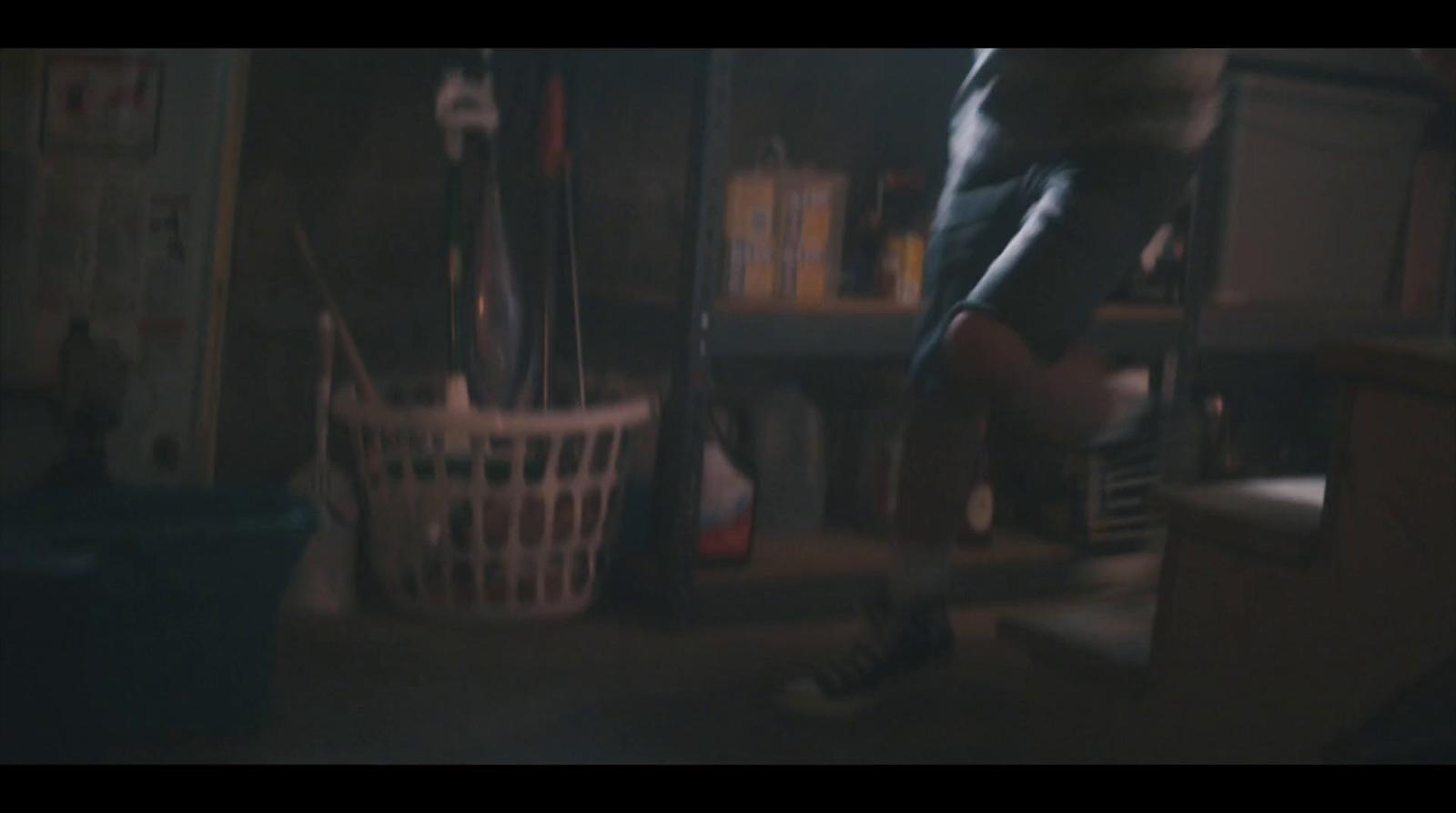 a person standing in a dark room next to a white basket