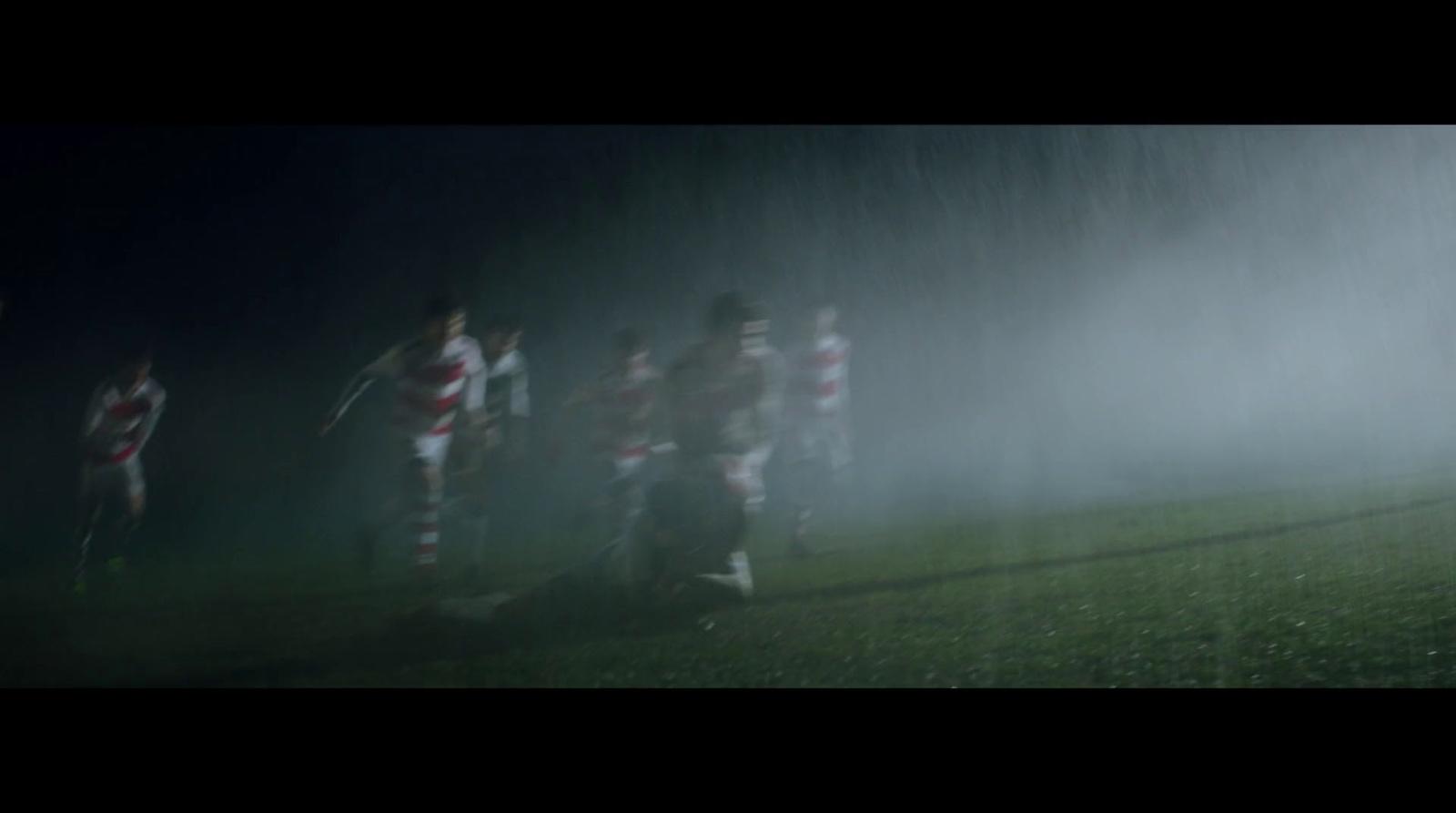 a group of soccer players playing in the rain