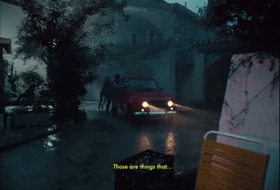 a man driving a car down a street in the rain