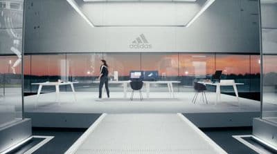 a person standing in a room with a desk and chairs