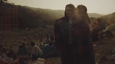 a man and woman standing in front of a crowd of people