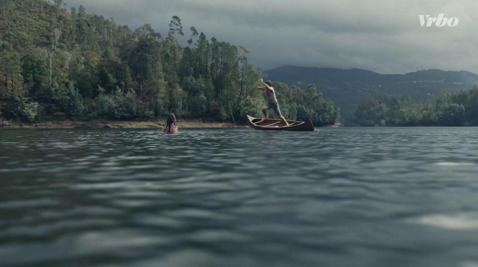 a man standing on a boat in the middle of a lake