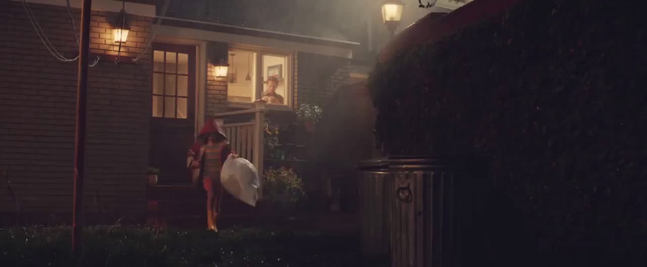 a woman holding a surfboard standing in front of a house