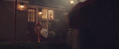 a woman holding a surfboard standing in front of a house