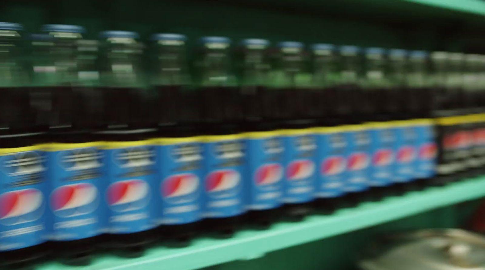 a row of soda bottles sitting on top of a shelf