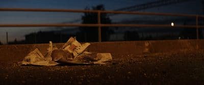 a pile of newspaper sitting on the side of a road