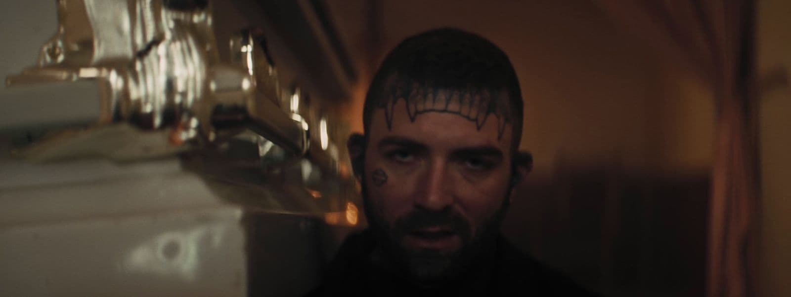 a man with a bald head and tattoos on his face