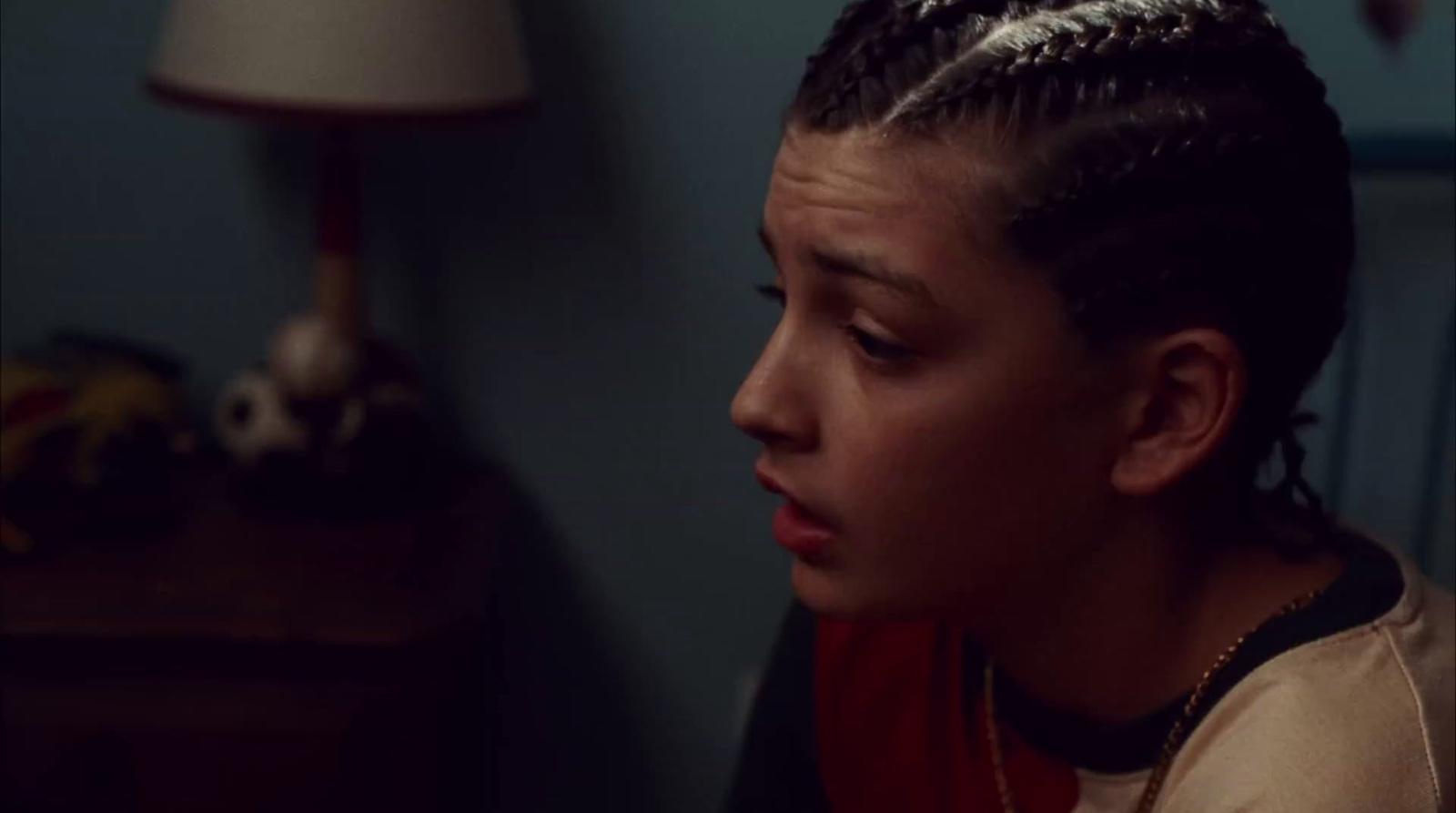a woman with braids on her head looking at something