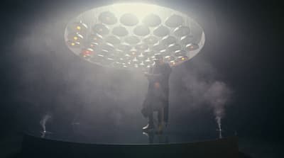 a man standing on top of a stage holding a light